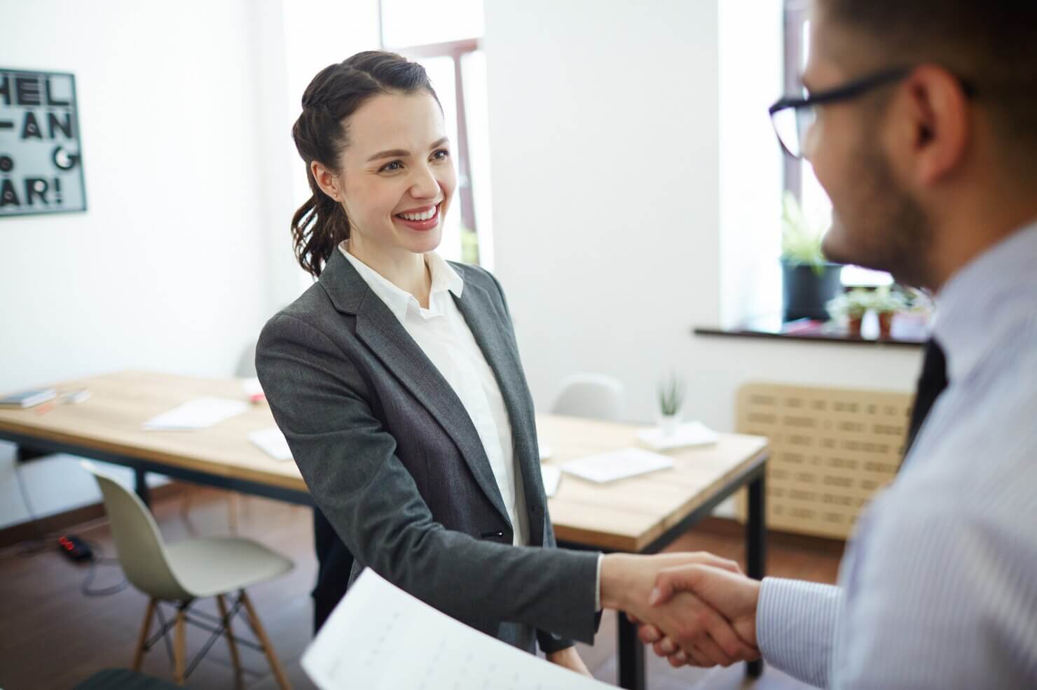 Businesswoman and employee shaking hands. Candidate is provided with continuous feedback during IT recruitment